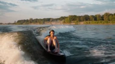 Wakeboard 'a atlayan dişi bir sörfçü. Deneyimli bir wakeboardcu kameraya su damlatıyor..