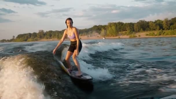 Una surfista saltando sobre un wakeboard. Un wakeboarder experimentado salpica el agua cae en la cámara. — Vídeo de stock