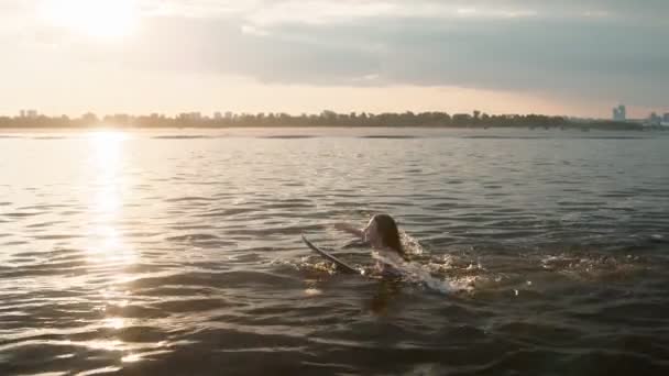 Una mujer nada en un wakeboard y sonríe — Vídeo de stock