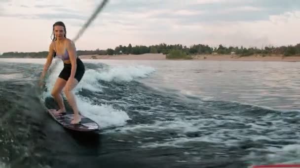 Egy női szörfös ugrál az éjjeliszekrényen. Egy tapasztalt wakeboardos vizet fröcsköl a kamerába..