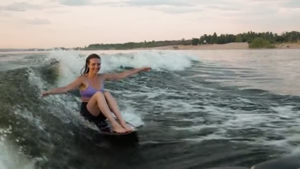 Surfařka skákající na wakeboardu. Zkušený wakeboardista cáká vodu kapky do kamery. — Stock video