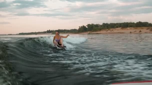 Une surfeuse sautant sur un wakeboard. Un wakeboarder expérimenté éclabousse des gouttes d'eau dans la caméra. — Video