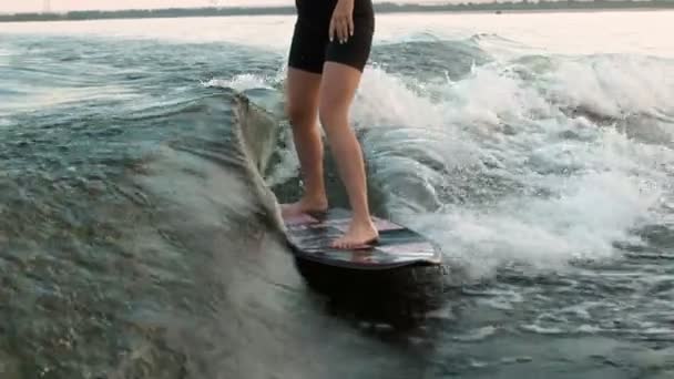 Uma surfista a saltar num wakeboard. Um wakeboarder experiente espirra água cai na câmera. — Vídeo de Stock