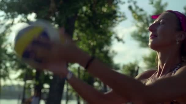 Radostné mladé ženy hrají plážový volejbal na krásném letním večeru — Stock video