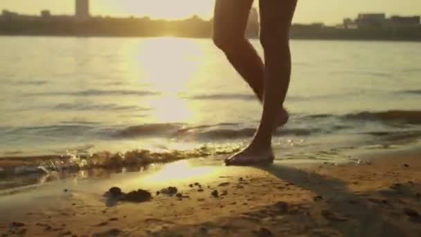 Barfüßige Frauen spazieren an einem Sandstrand und einem wunderschönen Sonnenuntergang — Stockvideo