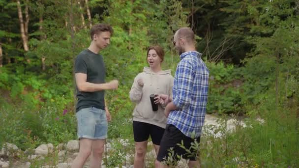 Un gruppo di tre persone che giocano a un gioco di carta-forbici mentre sono in piedi in una foresta circondata da alberi in una giornata estiva. All'aperto. — Video Stock