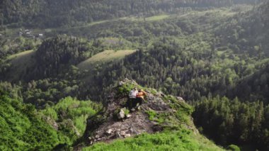 Genç bir kadın ve bir adam dağlık bir bölgede bir uçurumda yatıyorlar. Seyahat