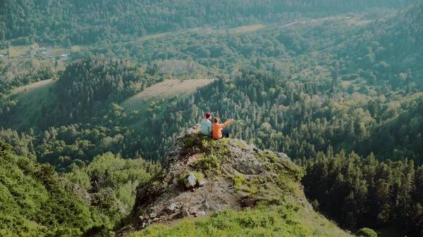 若い女性が山岳地帯の崖に男に近づく。旅行 — ストック写真