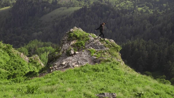 Una ragazza è in piedi su una scogliera tra le montagne. Viaggio — Foto Stock