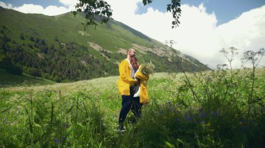 Genç bir adam arkasında sarı pelerinli bir buket çiçekle yürür, kıza yaklaşır ve dağlık alanlardaki bir çayırda ona bir hediye verir. Seyahat ve Turizm