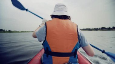 Genç bir adam güzel bir manzaraya karşı nehirde kayak yapıyor. Seyahat et. Turizm.