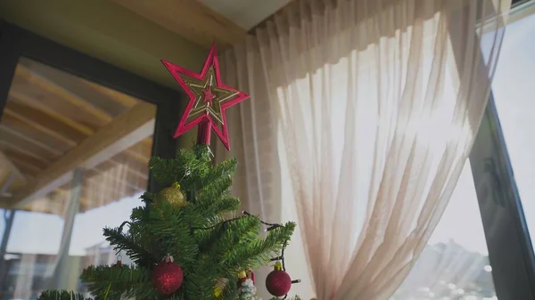 A decorated Christmas tree next to the window in the house. New Year. — Stock Photo, Image