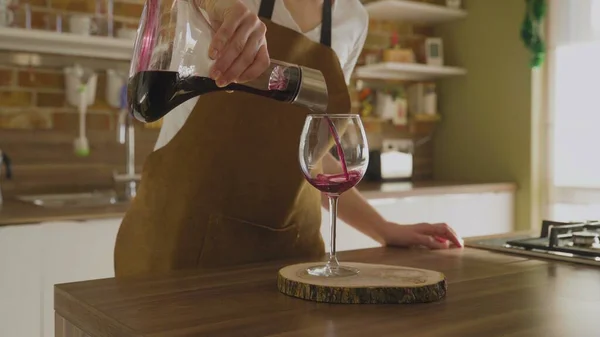 Неузнаваемая женщина наливает вино из графина в красивый стакан. Крупный план. — стоковое фото