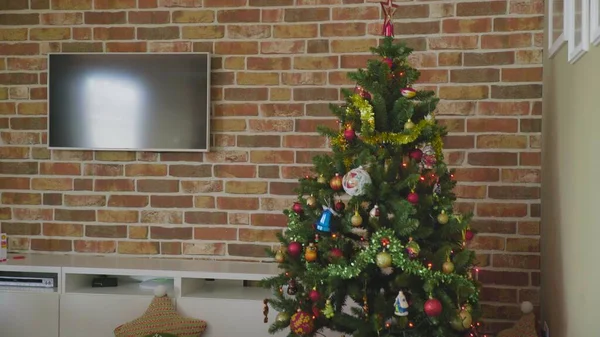 В углу дома находится рождественская елка с кучей подарков под ней, а вокруг елки едет игрушечный поезд. Уютная атмосфера — стоковое фото