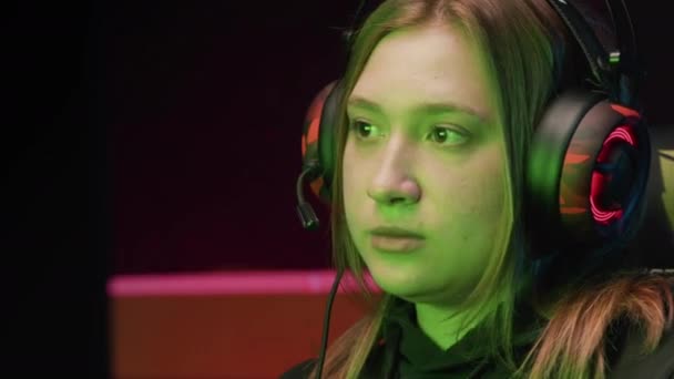 Close-up of a young girl playing on a computer with headphones — Stock Video