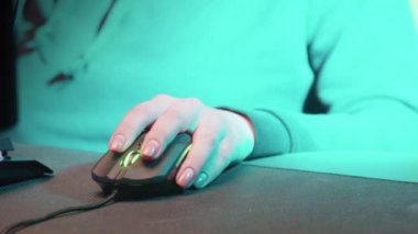 Kız eli bilgisayar faresiyle oynuyor. Yakın plan.