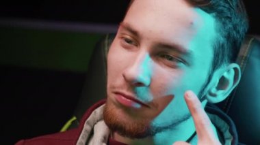 Bilgisayar kulübünde bilgisayar oynayan düşünceli bir gencin yakın çekimi.