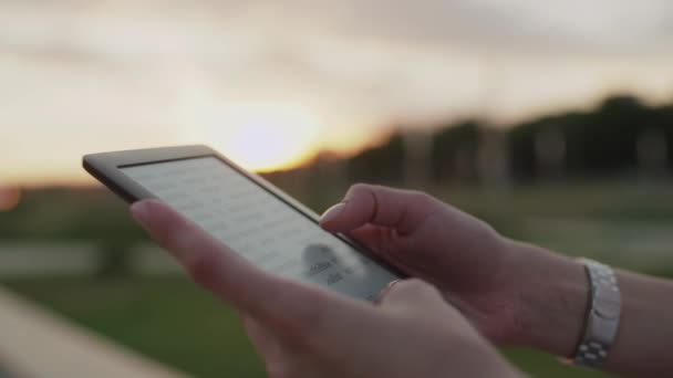 Les mains des femmes tiennent un livre électronique — Video