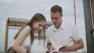 Açık havada bir adam ve bir kız bir e-kitap okudu.