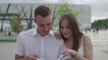 Açık havada bir adam ve bir kız bir e-kitap okudu.