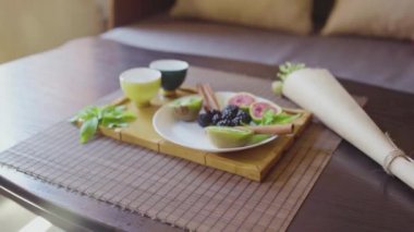 Ahşap tepside mis kokulu yeşil çay tabağında lezzetli meyve tabağı.