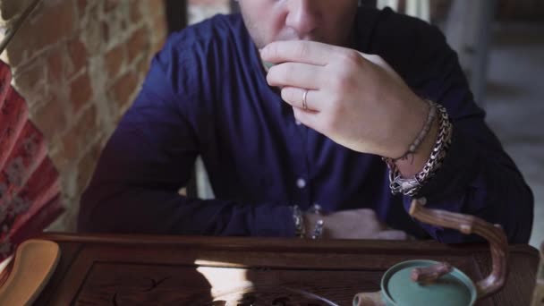 Un bărbat bea ceai verde dintr-un set de ceai într-o cameră de ceai — Videoclip de stoc