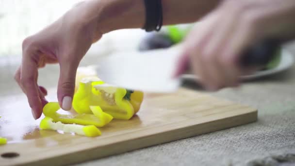 Κοντινό πλάνο του τεμαχισμού γλυκό πιπέρι με ένα μαχαίρι κουζίνας — Αρχείο Βίντεο