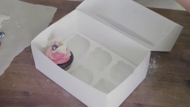 Top view ένα κορίτσι βάζει cupcakes σε ένα όμορφο κουτί δώρου — Αρχείο Βίντεο