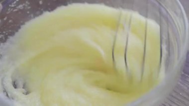 Fırıncı elleri hamuru cam bir kasede çırpıcıyla yoğurur. Yemek hamuru, yemek malzemeleri, üst manzara.