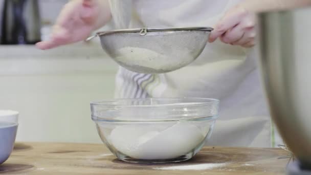 A girl in the kitchen pours flour into a glass bowl close-up — Stock Video