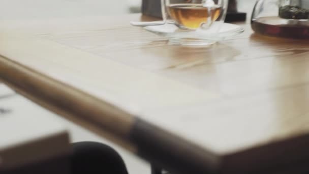 Um homem pega uma caixa de presente debaixo da mesa e coloca-a na mesa em um café ou restaurante close-up — Vídeo de Stock