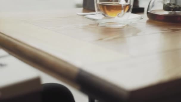 A man takes a gift box from under the table and puts it on the table in a cafe or restaurant close-up — Stock Video