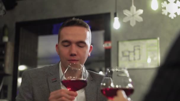 Egy férfi randin egy nővel egy kávézóban vagy étteremben, aki bort iszik közelről. — Stock videók