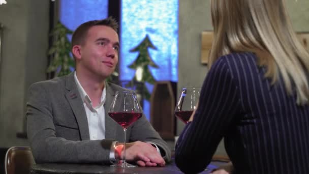 Un uomo ad un appuntamento con una donna in un caffè o in un ristorante che beve vino primo piano — Video Stock