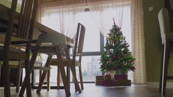 Evin penceresinin yanındaki Noel ağacının altında bir sürü hediye var. Yeni Yıl. — Stok video