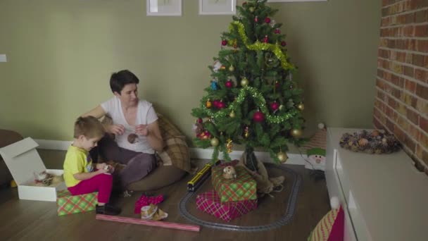 Anya és a gyerek díszítik a karácsonyfát. Karácsonykor. Ünnepi hangulat. — Stock videók