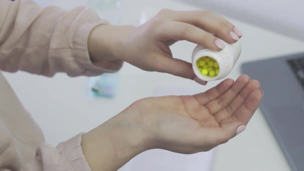 Желтые таблетки вынимаются из бутылки с лекарством и разбросаны по рукам девочек. Витамин С для повышения иммунитета. Аскорбиновая кислота в драже — стоковое видео