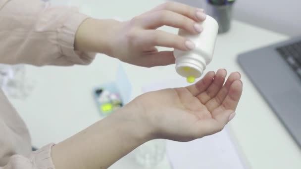 Egy felismerhetetlen lány kiveszi a tablettákat a kezéből, és lemossa vízzel, közelről. — Stock videók