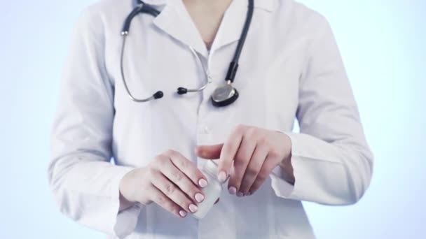 Närbild av en oigenkännlig kvinna, en läkare, hålla en burk piller och kasta den i hennes hand — Stockvideo