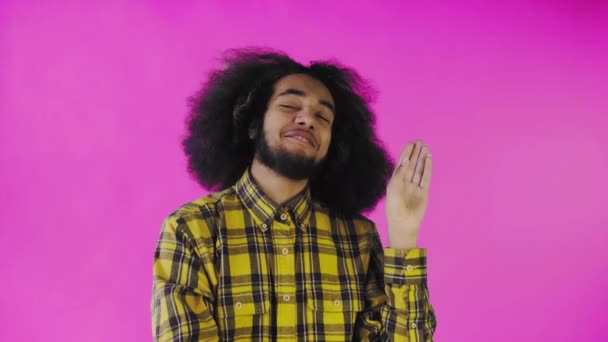 Bla, bla, bla. Een verveelde Afro-Amerikaan, gebaar met een blah-blah gebaar, moe van gesprekken en oninteressante informatie, poseren op een roze achtergrond — Stockvideo
