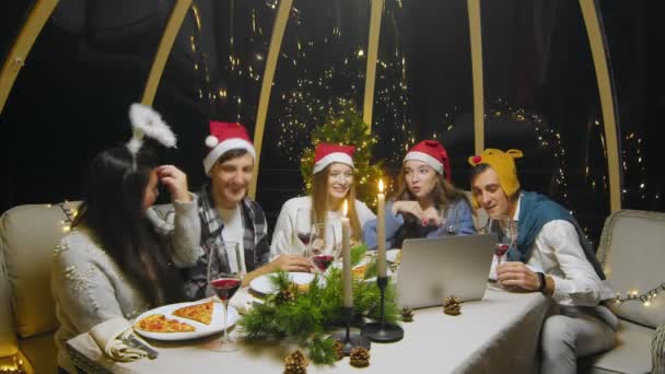 Friends celebrate the New Year at the dinner table. Students watching a movie on a computer during a Christmas party at home — Stockvideo