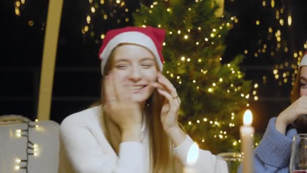 Close-up of a laughing girl for the New Year. Friends celebrate the New Year at the dinner table. — Stockvideo