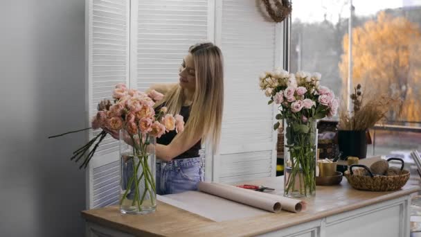 Una giovane bella donna impegnata in floristica inizia a raccogliere i migliori fiori per la sua composizione floreale. Fiorai — Video Stock