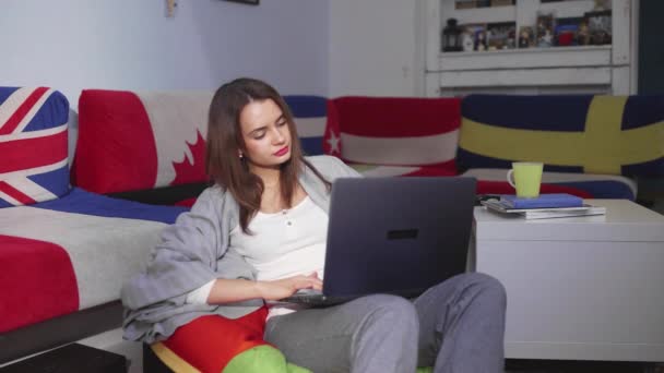 Una giovane donna è seduta in una stanza di un computer, guardando attraverso un notiziario. Tempo libero. — Video Stock