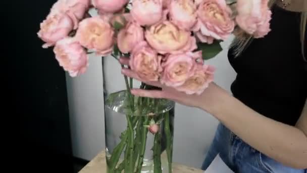 Uma jovem mulher bonita envolvida em floricultura começa a recolher as melhores flores para o seu arranjo de flores. Floricultura. Close-up — Vídeo de Stock
