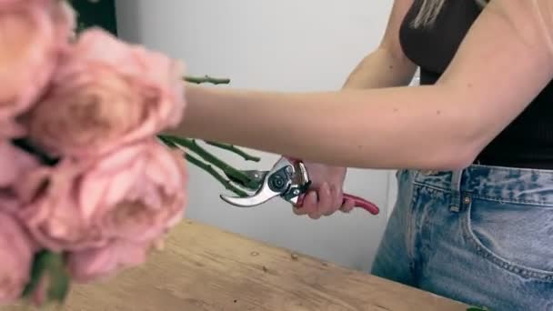 Mladá krásná žena zabývající se floristií začne sbírat nejlepší květiny pro její květinové aranžmá. Floristry. Detailní záběr — Stock video