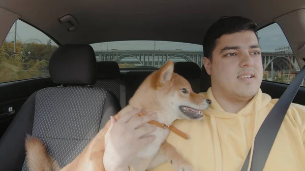 A guy rides in a car with a dog. People and animals ride in a car — Stok fotoğraf