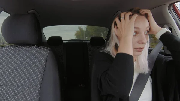 The girl behind the wheel of the car looks in the mirror. People are driving in a car — Stock fotografie