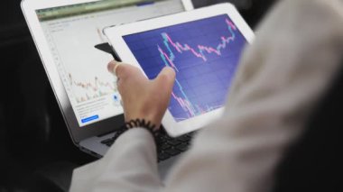 Kızın elinde Online Borsa Çizelgesi 'nde Bearish ve Bullish Trends of Bitcoin' in olduğu bir tablet var. Gerçek zamanlı olarak..