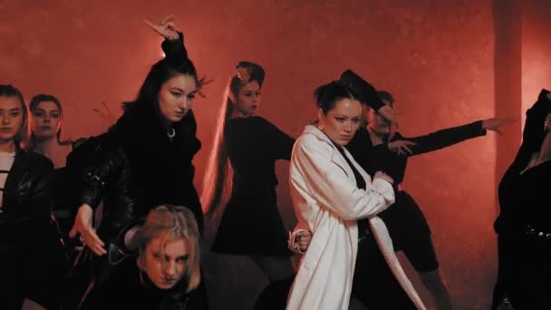 Skupina krásných dívek tančících v místnosti s červeným světlem v černých oblecích. Tanec — Stock video